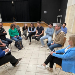 Une dizaine de personnes assises en cercle sur leur chaise